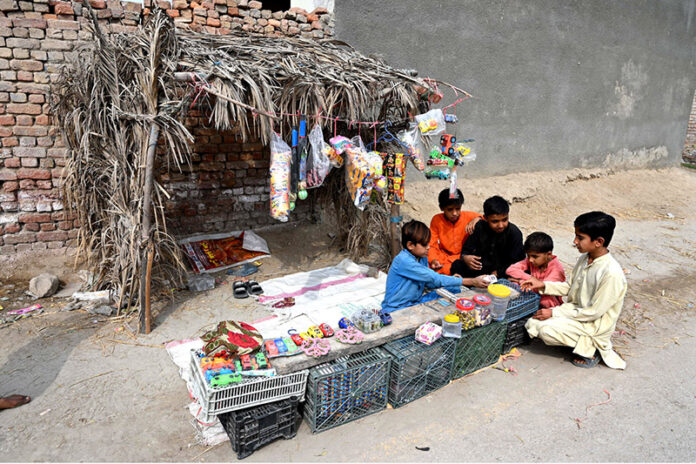 A boy selling toys and other items outside his makeshift hut to earn for livelihood at Otha Chowk Road