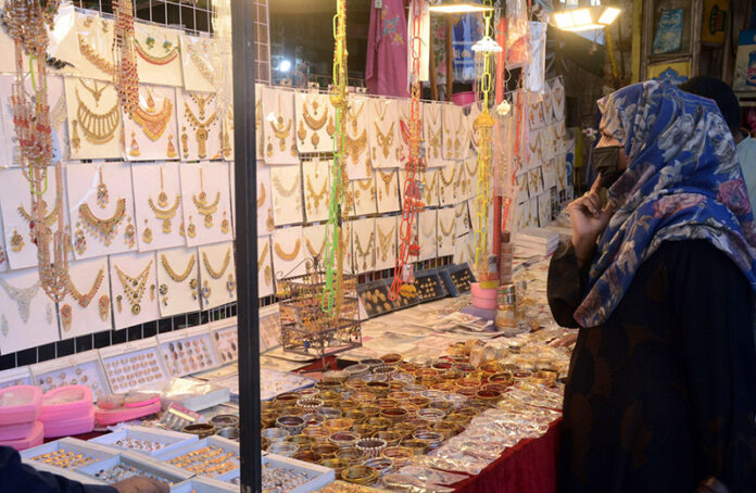 A woman looking for jewelry during Eid-ul-Fitr shopping at Anarkali market