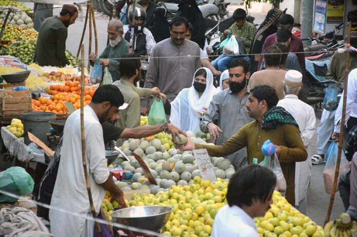 People are busy purchasing fruits from vendors for Iftar in the Saddar area during the holy fasting month of Ramzan-ul-Mubarak