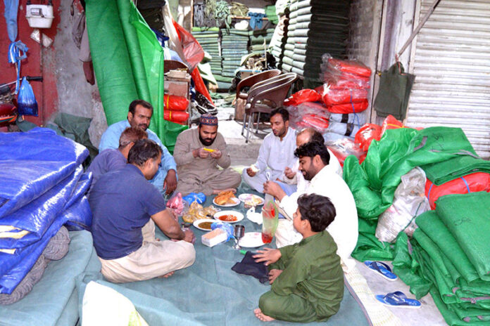 Workers breaking fast in holy Ramadan at the Tarpaulin sheet Market