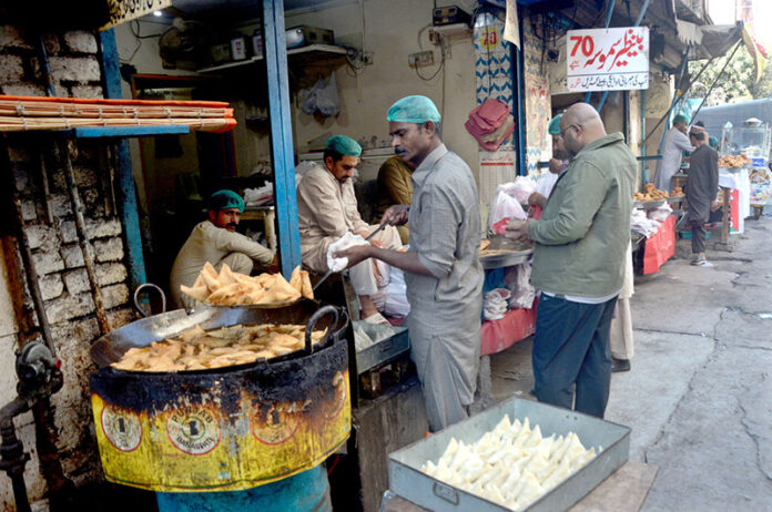 Vendors frying food stuff ‘Samosa’ for Iftar in the fasting Month of Ramadan