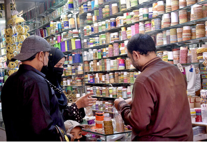 A woman selecting bangles at a shop in Dharmapura Bazaar in preparation of the upcoming Eid al-Fitr