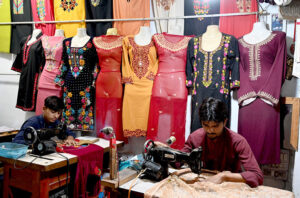 A tailor master at his work place is busy as per work demand due to preparation for upcoming Eid ul-Fitr.