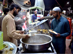 A vendor displaying and selling traditional food stuff to customers for Sehri at Gwalmandi Food Street during the Fasting Month of Ramzanul Mubarak