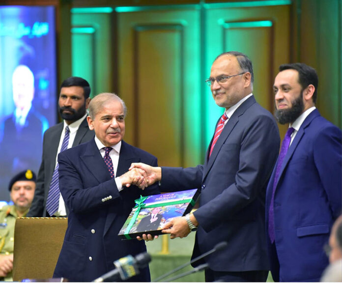 Prime Minister Muhammad Shehbaz Sharif being presented a book on one year performance of the government by Minister for Planning & Development Prof Dr Ahsan Iqbal and Minister for Information & Broadcasting Attaullah Tarar during the Special Meeting of the Cabinet at Jinnah Convention Center