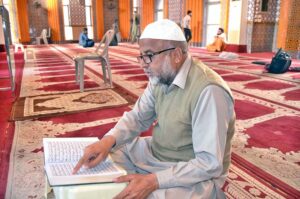 A faithful is reciting the Holy Quran in Jamia Masjid Minhaj-ul-Quran during the holy fasting month of Ramzan-ul-Mubarak.