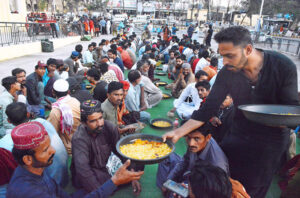 A large number of people break their fast at a free Iftar along the roadside in the holy month of Ramzan ul Mubarak.