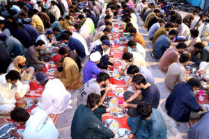 A large number of people breaking fast (Iftar) in the holy month of Ramazan ul Mubarak arranged by market shopkeeper.