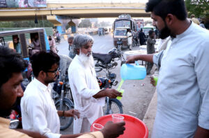 Volunteers serving to Juice to people during breakfast (Iftar) in the holy month of Ramzan ul Mubarak at road side in city.