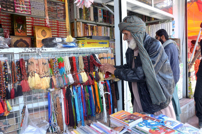 An aged man looking for Tasbih at Meezan Chowk