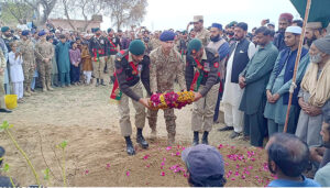 Lieutenant Colonel Aamir Rajefar is laying a wreath on behalf of the President of Pakistan at the grave of Naik Muhammad Usman, who was martyred by terrorists in the Express incident