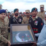 Commanding Officer 53 Field Regiment Lieutenant Colonel Sohail Akhtar presenting a uniform to Muhammad Riaz, father of Pakistan Army Naik Muhammad Usman, who who embraced Shahadat during terrorists attack on Jaffar Express